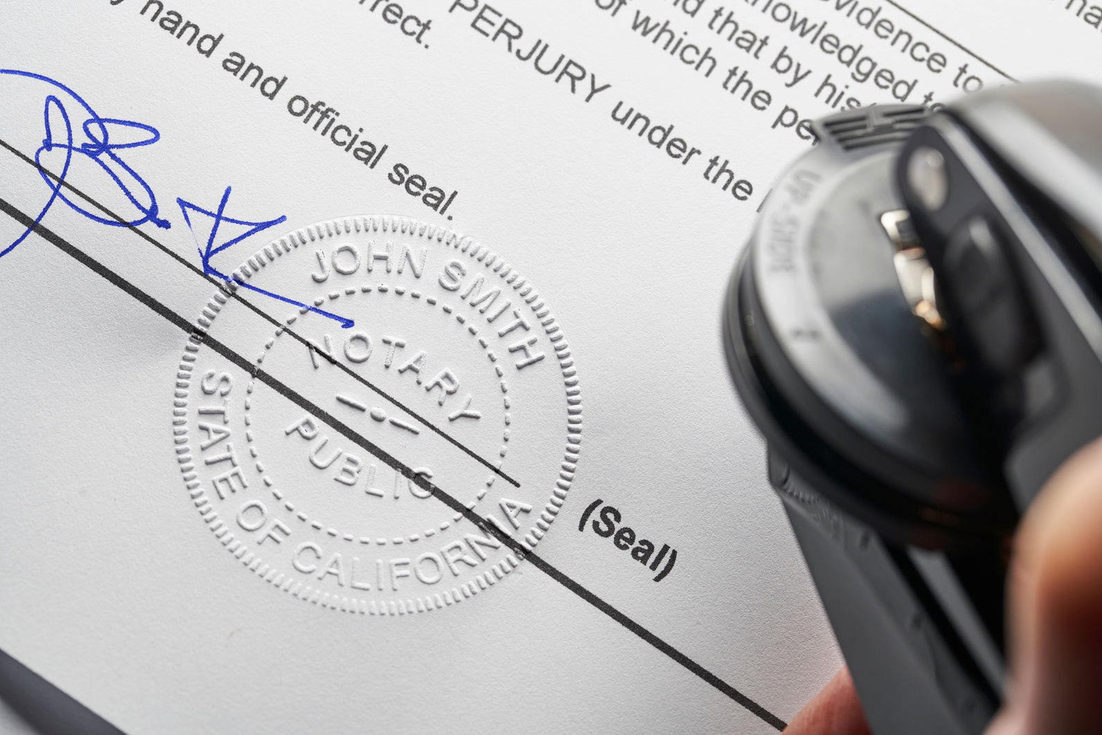 Notary Public: Seal embossed on document with pen and glasses